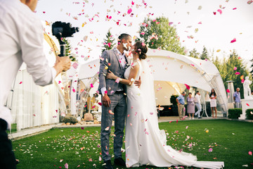 photographer shoots couple in rose petals