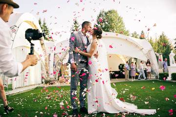 photographer shoots couple in rose petals