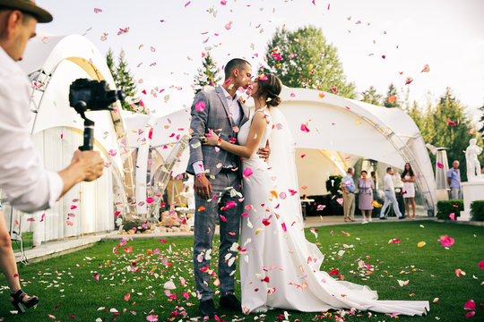 photographer shoots couple in rose petals