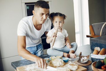 Family in a kitchen. Handsome father with little daughter