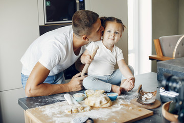 Fototapeta premium Family in a kitchen. Handsome father with little daughter