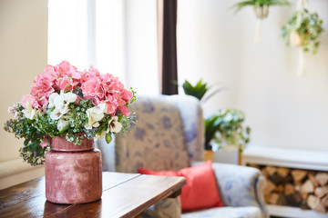a bouquet of flowers in a vase on the table in the room. shabby style