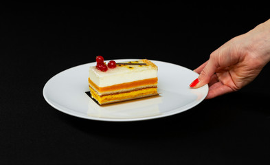 multi layered beautiful cake with white cream and red currants, on a white plate, dessert serving