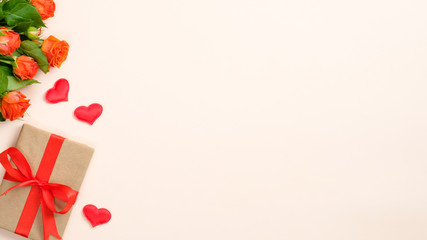 Valentines day card with roses flowers, gift box, hearts on pastel beige background. Flat lay, top view, copy space.