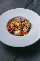 Close-up vertical shot Vegetarian paella with octopus on a white plate. Mediterranean food. Ketogenic Diet Recipes