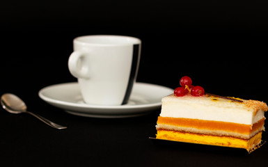 multilayer cake with airy white cream and red currant, mouth watering dessert, white cup with a small spoon