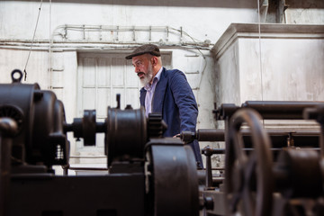 Obraz na płótnie Canvas Tired worker working on a printing press