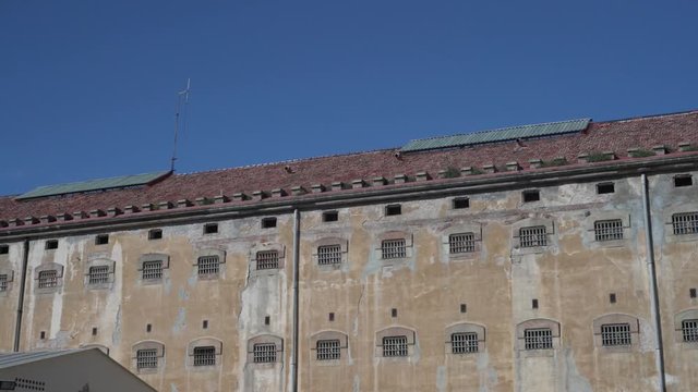 Panoramic view of prison building with windows of prison cells with metal bars