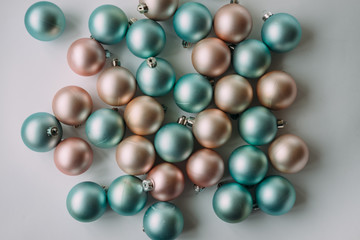Christmas balls of mint and peach color on a light background.