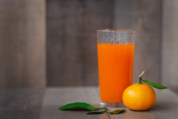 The fresh juice of citrus fruits on the wooden background. Close up