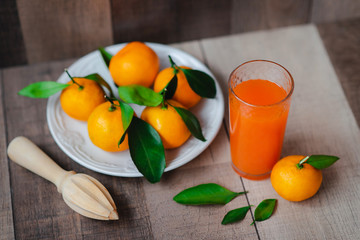 Glass jar of fresh orange juice with fresh fruits on wooden table
