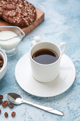 Cup of hot coffee on color background