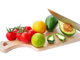 Guacamole avocado spread ingredients on wooden board over white background