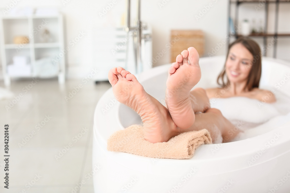 Poster Beautiful young woman relaxing in bathtub