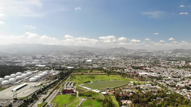 Aerial panoramic view of Parque Bicentenario in Mexico City. Drone flying forward with a blue sky as background.