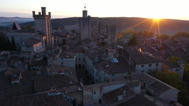 Sun rising over a hill aerial view of Uz&egrave;s France Gard Duchy castle 