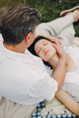 Fototapeta premium Adult couple in a summer field. Handsome senior in a white shirt. Woman in a white blouse