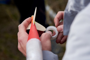 The guy holds in his hands a model of a rocket and prepares it for flight.