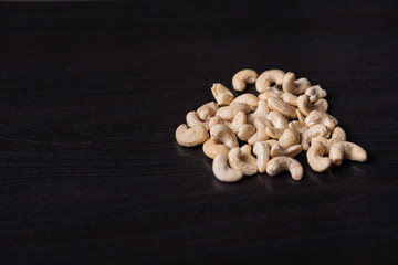 Cashewkerne auf dem schwarzen Holzbrett