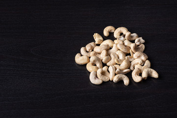 Cashewkerne auf dem schwarzen Holzbrett