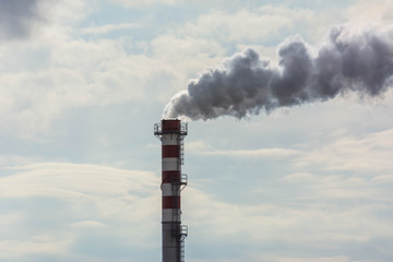 Red and White Chimney Smoking on Cloudy Sky Background