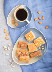 traditional arabic sweets and a cup of coffee on a gray concrete background.  top view, close up.