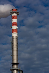 Red and White Chimney Smoking on Cloudy Sky Background