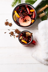 Christmas mulled Wine with orange, apple, cinnamon, cranberry and spices on the white wood table top view. Winter traditional hot drink.