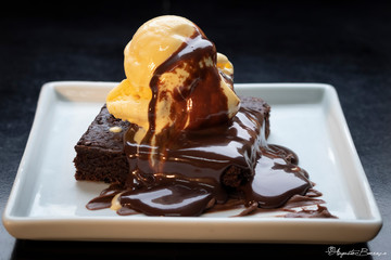 petit gateau, bolo de brownie com uma bola de sorvete encima derretendo e chocolate