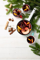 Christmas mulled Wine with orange, apple, cinnamon, cranberry and spices on the table top view. Winter traditional hot drink.