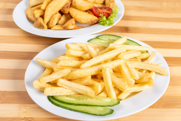 French fries slices, and chopsticks on a plate. With greens.