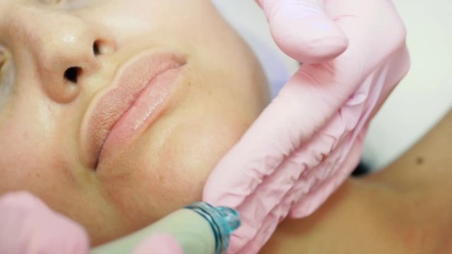 Cosmetology. Closeup of young woman getting lifting procedure in a beauty parlour. Hydrafacial massage process.