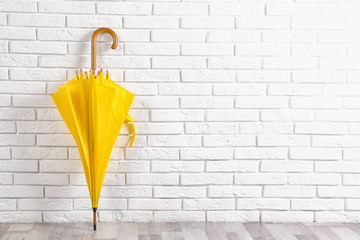 Beautiful yellow umbrella near white brick wall. Space for text © New Africa