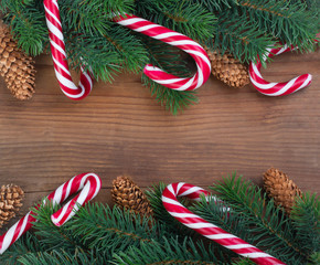 Christmas tree branch decorated with garlands, cones and caramel sticks