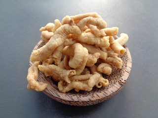 Close up view of kripik keripik usus ayam or gut chicken fried snack fritters crackers on the bowl. traditional menu from Indonesia. Clean bowels inside, covered with flour, then frying on hot oil