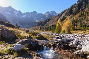 Fototapeta na wymiar kleiner Bach in herbstlicher Hochgebirgslandschaft im Zillertal in Tirol