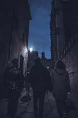 Fototapeta na wymiar Guys Walking Down an Alley at Night
