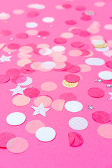 Multicolor pink, gold and white confetti on the bold pink background, holiday celebration backdrop, Flat lay style
