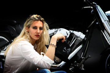 Fototapeta na wymiar Blond rebel woman sitting next to her motorcycle