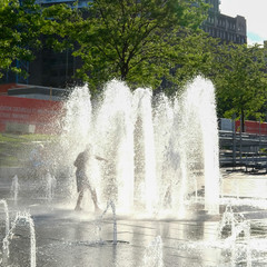 Silhouette of a child having fun in a fountain