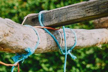 Ropes is knotted around wooden fence. Close-up natural texture