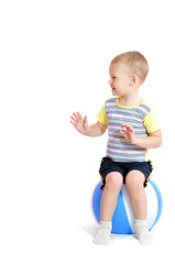 Little boy sits on inflatable ball