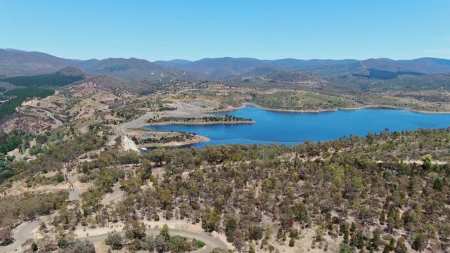 High angle aerial footage of Cotter Dam and Cotter reservoir, a supply source of potable water for the city of Canberra in the Australian Capital Territory, Australia. Low water levels due to drought.