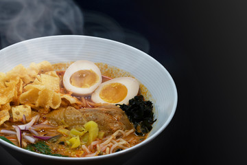 Hot delicious Japanese chicken curry ramen noodles in black background. Copy Space.