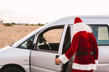Santa Claus getting into a van to work as a delivery man