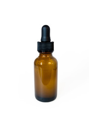 Cannabis extract oil, known as CBD, in an orange tincture bottle on a plain white background
