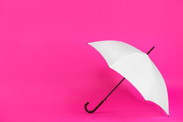 Beautiful white umbrella on pink background. Space for text