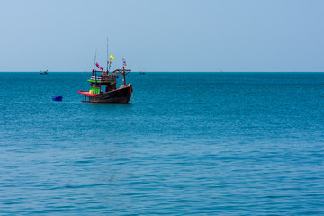 Naklejka na ściany i meble A small fishing boat anchored near Bang Saen Beach in the Gulf of Thailand.