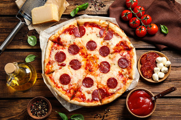 Flat lay composition with hot pepperoni pizza on wooden table