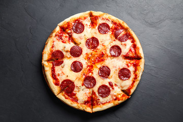 Hot delicious pepperoni pizza on dark table, top view